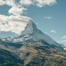 Stunning view of the Matterhorn in Zermatt, Switzerland with a cloud-capped peak on a clear day.