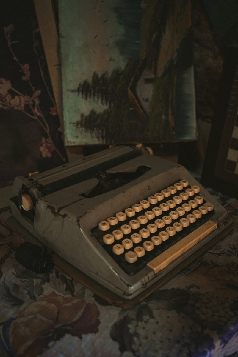 Old typewriter with a vintage feel against a creative backdrop of paintings.