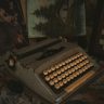 Old typewriter with a vintage feel against a creative backdrop of paintings.