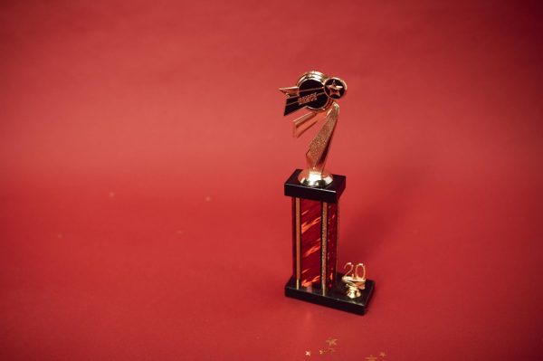 Golden trophy standing on a vibrant red background, symbolizing success and achievement.