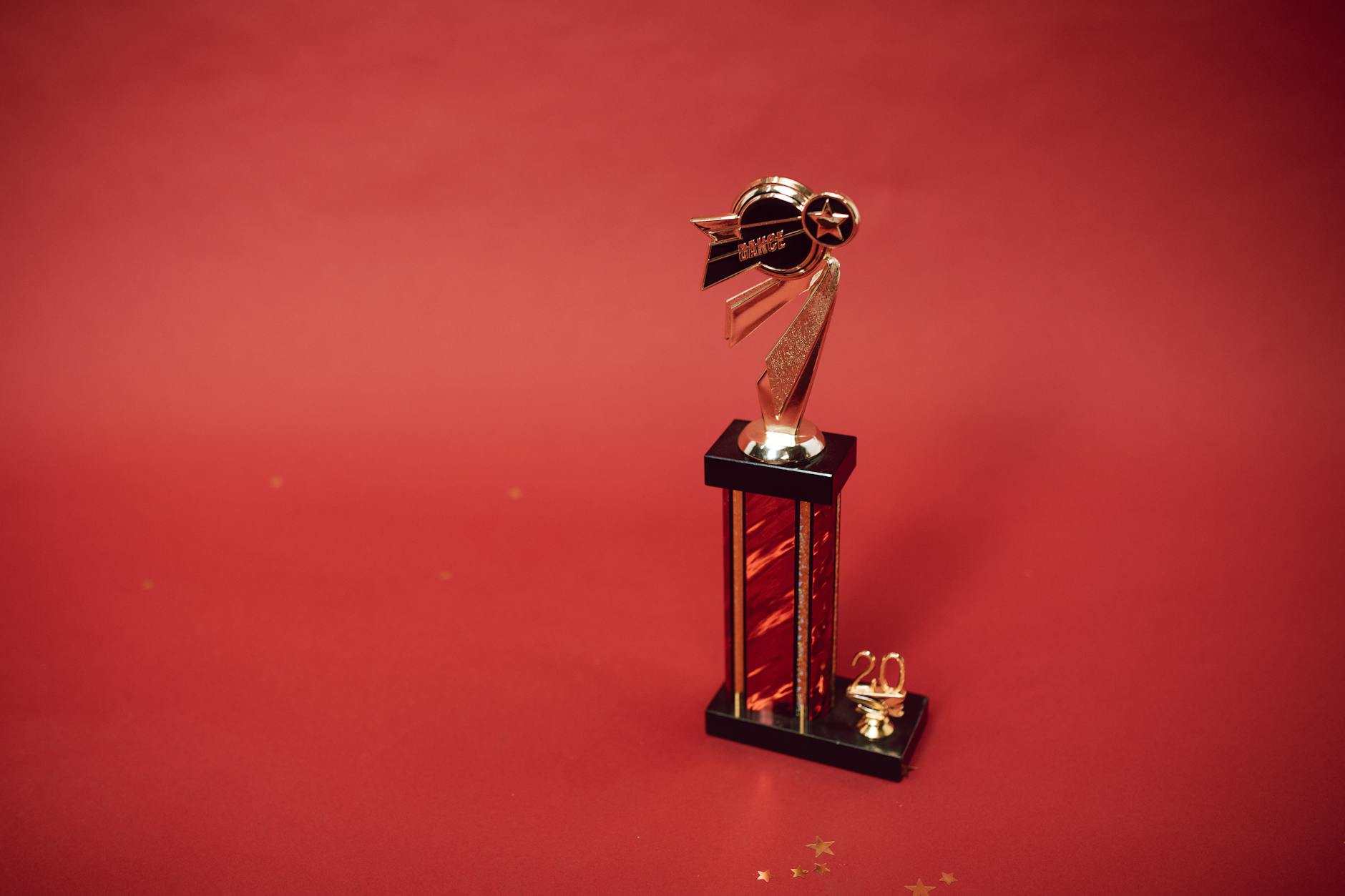 Golden trophy standing on a vibrant red background, symbolizing success and achievement.