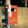 EV charging station at night with a blurred background, offering eco-friendly transportation solutions.