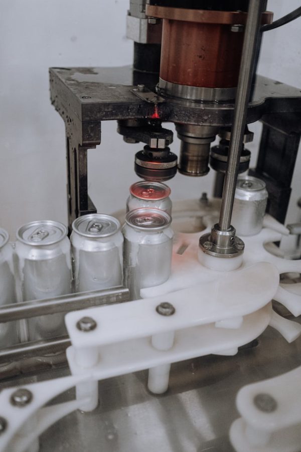 Close-up of beverage cans on an automated assembly line in a factory.