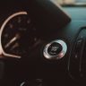 Close-up of a luxury car dashboard featuring a start stop button and sleek design.