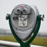 Close-up of a coin-operated viewer on a rainy day, perfect for observing scenic landscapes.