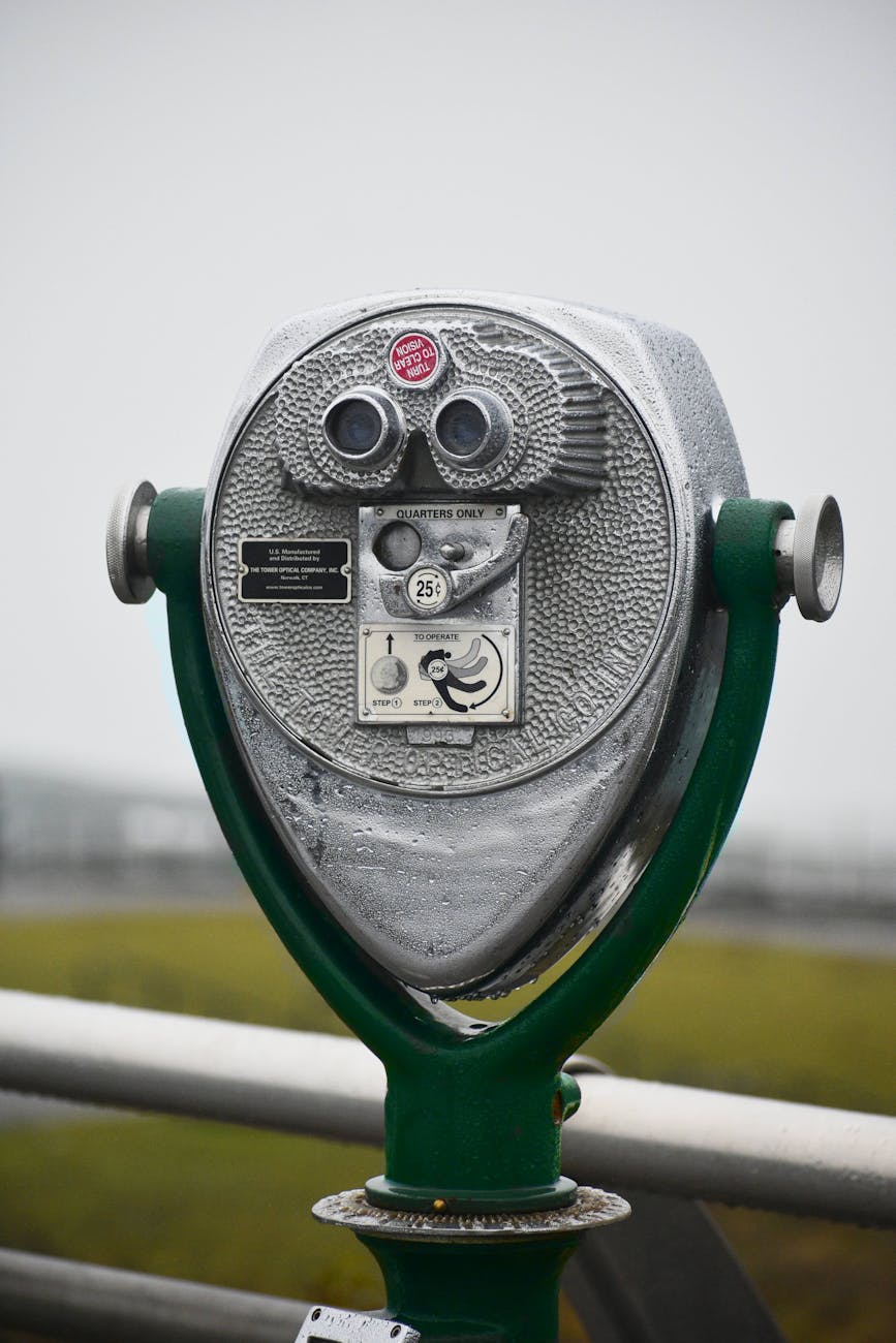 Close-up of a coin-operated viewer on a rainy day, perfect for observing scenic landscapes.
